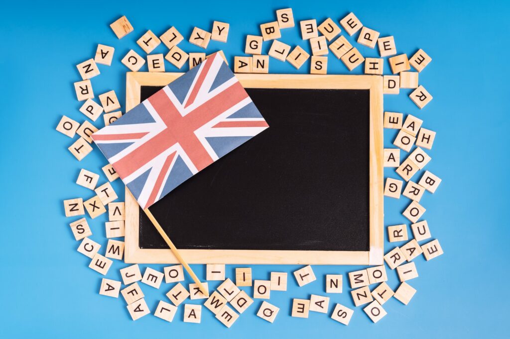 Chalk board with british flag and latin letters on blue background