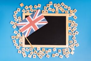 Chalk board with british flag and latin letters on blue background