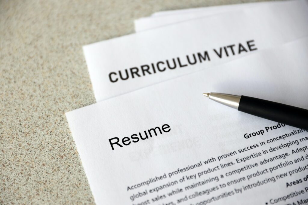 Top view of stack of office documents including resume and teaching cv forms